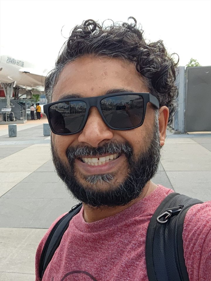 Neal, the founder of Natty, smiling outdoors in sunglasses